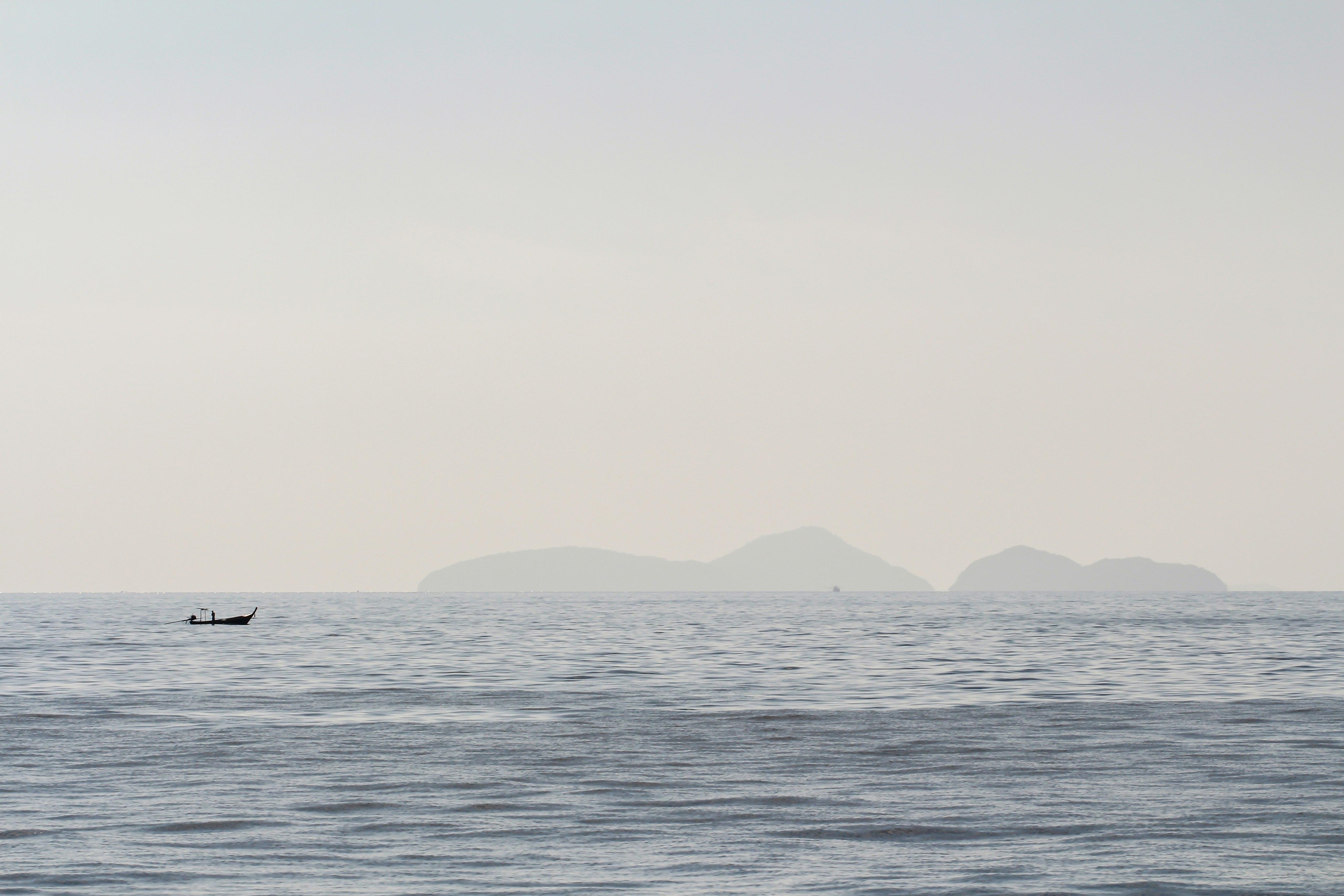 silhouette of boat sailing on ocean